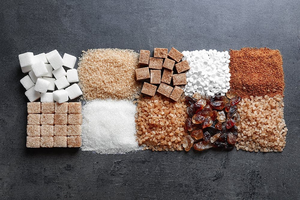 Different forms of sugar on a grey background