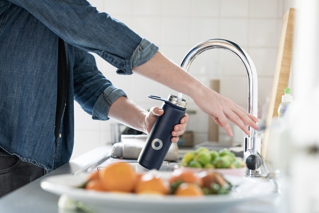 Get rid of brain fog: Person filling a water bottle
