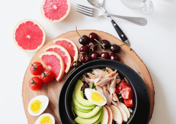 Platter of sliced fruit, egg, and cherries