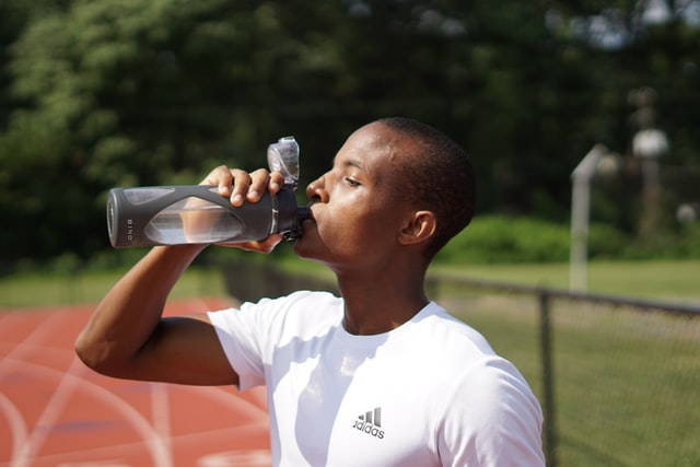 Man drinking water to prevent sore muscles.