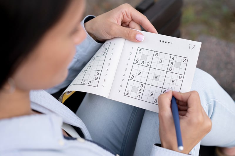 Person exercising their brain by doing sudoku