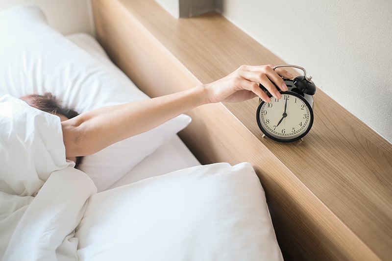 Woman hitting snooze button