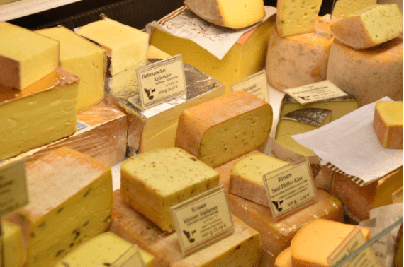 Foods to avoid with high cholesterol: A table full of different cheeses for sale
