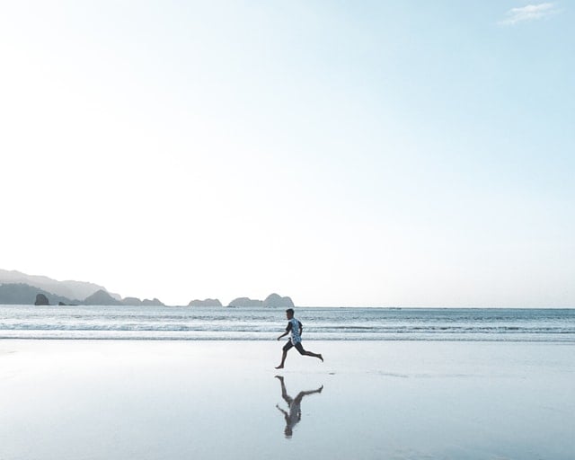 Types of Exercise: A person jogging on the beach 